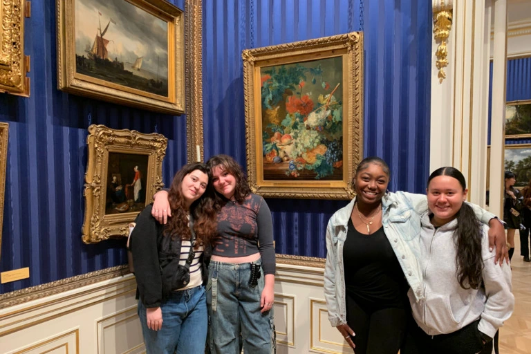 Four Verto students in front of paintings in an art musuem.