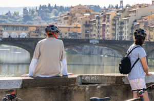 Students with bicycles looking out at the Ponte Vecchio.