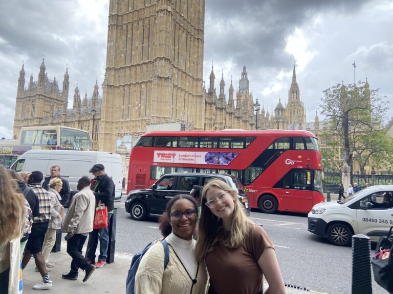 Verto students standing at the base of Big Ben with a red double decker bus.