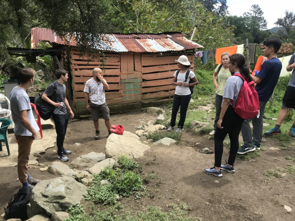 Verto Education students listening to a local guide during a community visit in a rural village abroad