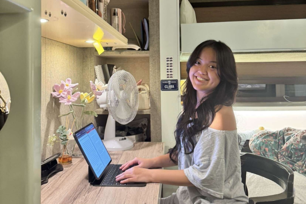 A Verto participant smiling in her dorm room at her computer. 