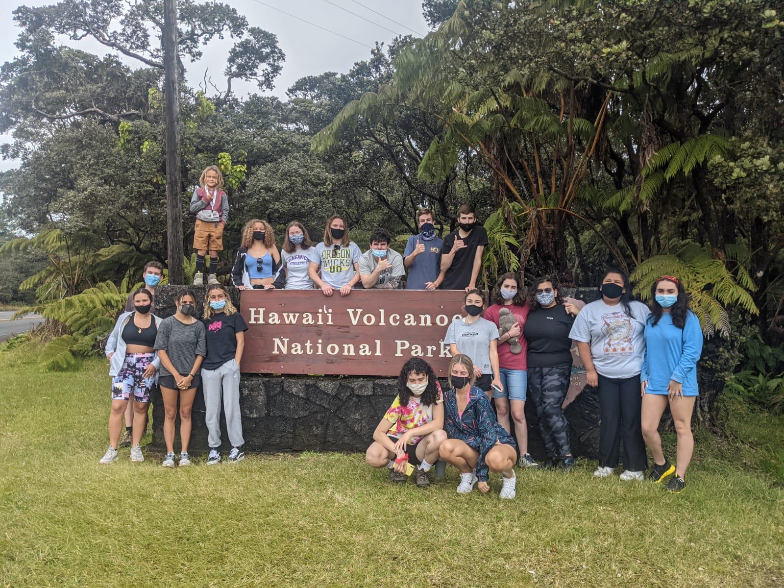 A group of students stand by the entrance to Volcanoes National Pakr