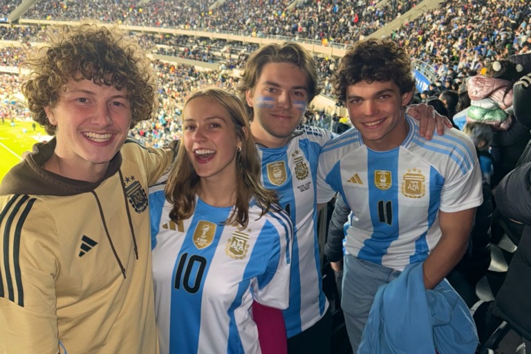 4 Verto students smiling at a Buenos Aires soccer game.