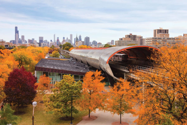 Photo: Train tracks laid toward the Chicago city skyline seen through the vibrant colors of Fall foliage.