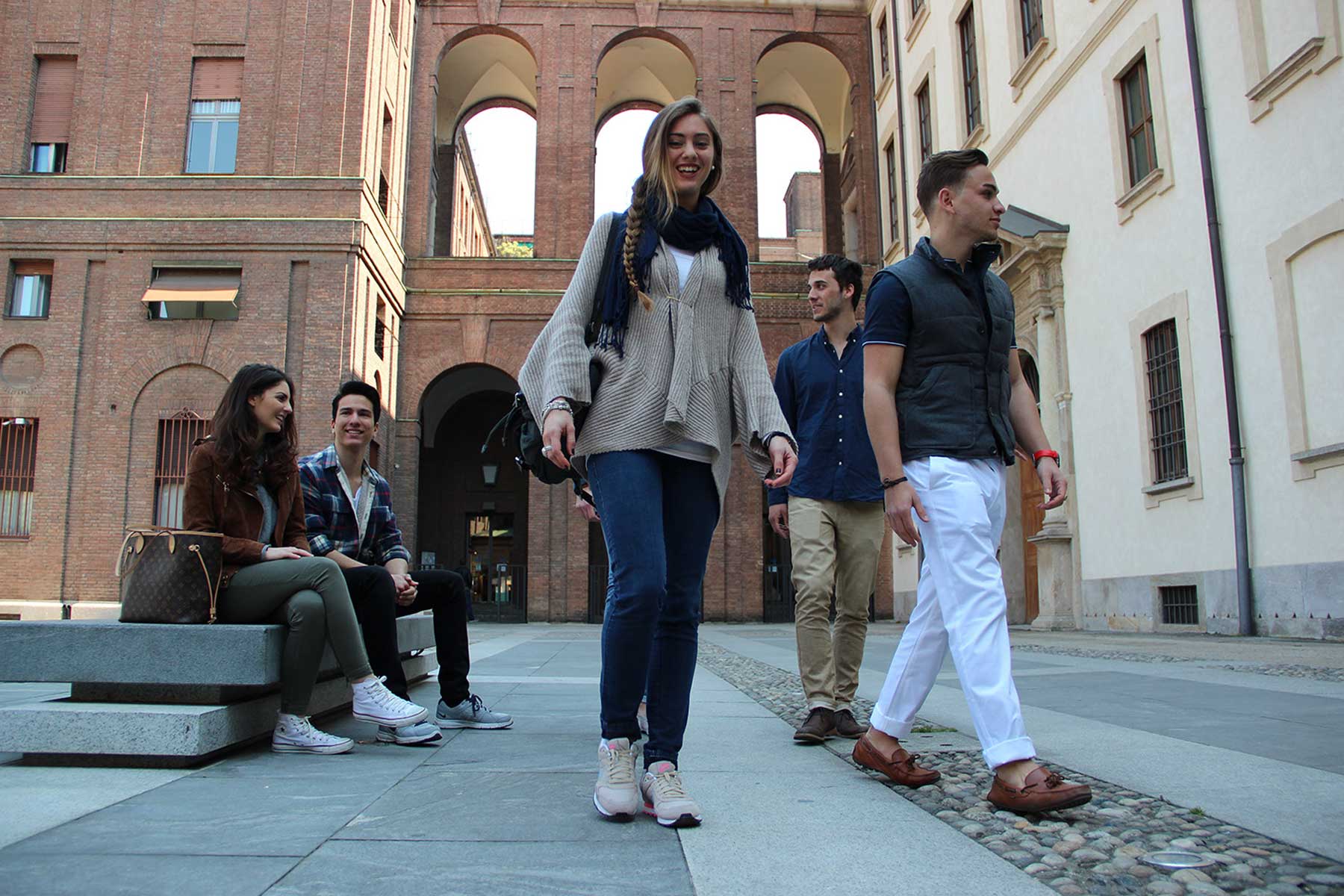 Photo: Students sitting walking through plaza