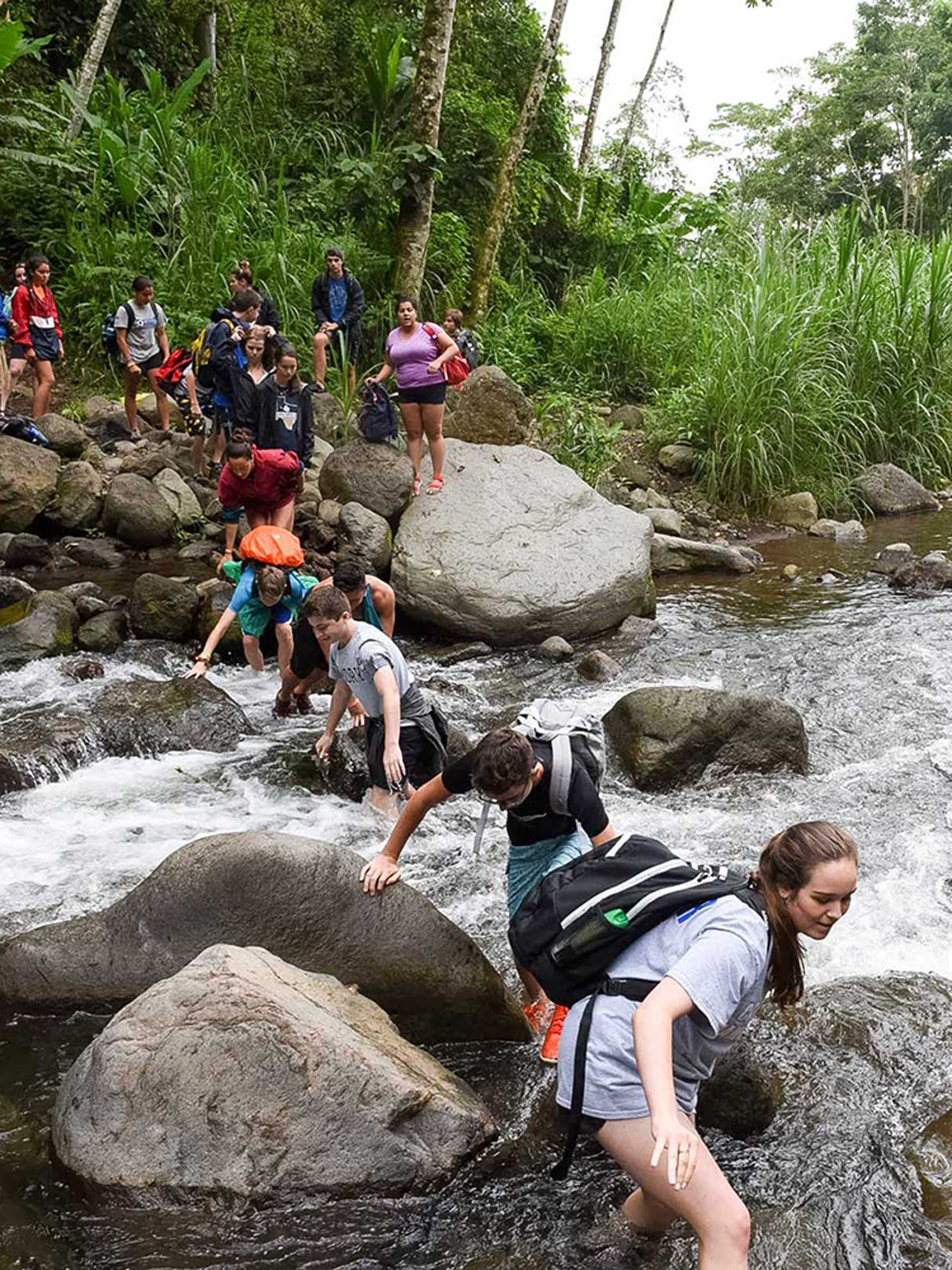 Photo: Verto Education students wade across river together in tropical Costa Rica jungle
